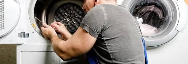 Dryer repair technician fixing a clothes dryer drum in Lakewood, CO