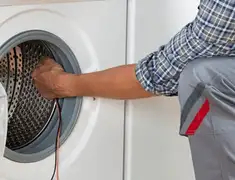 Dryer repair technician diagnosing and servicing a clothes dryer in Lakewood, CO