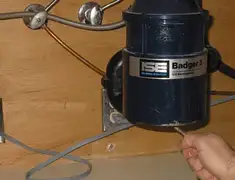 Garbage disposal repair technician tightening the mounting ring under a sink in Lakewood, CO