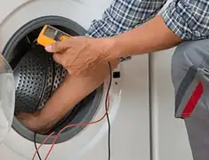 Washing machine repair technician testing a front-load washer with diagnostic tools in Lakewood, CO