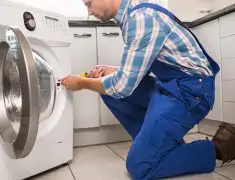 Washing machine repair technician servicing a front-load washer in Lakewood, CO