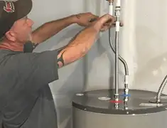 Water heater repair technician tightening supply line connections in Lakewood, CO