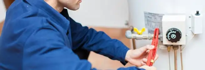Water heater repair technician adjusting the temperature control and gas valve in Lakewood, CO